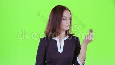 女人宣传两个比特币，并竖起大拇指。 绿色屏幕